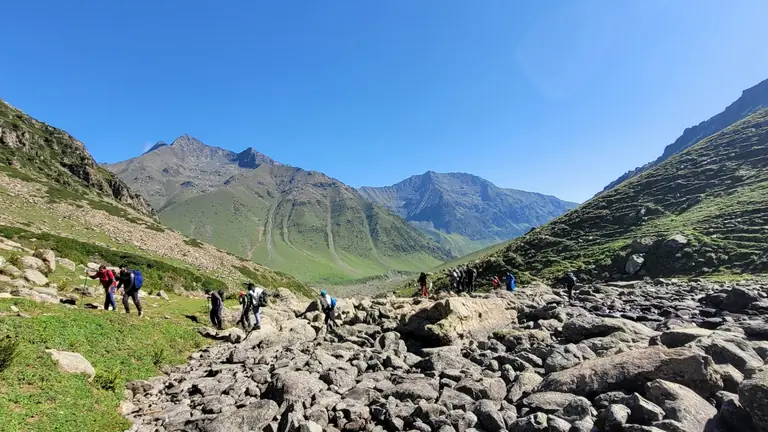 Group of travellers walking together through a valley